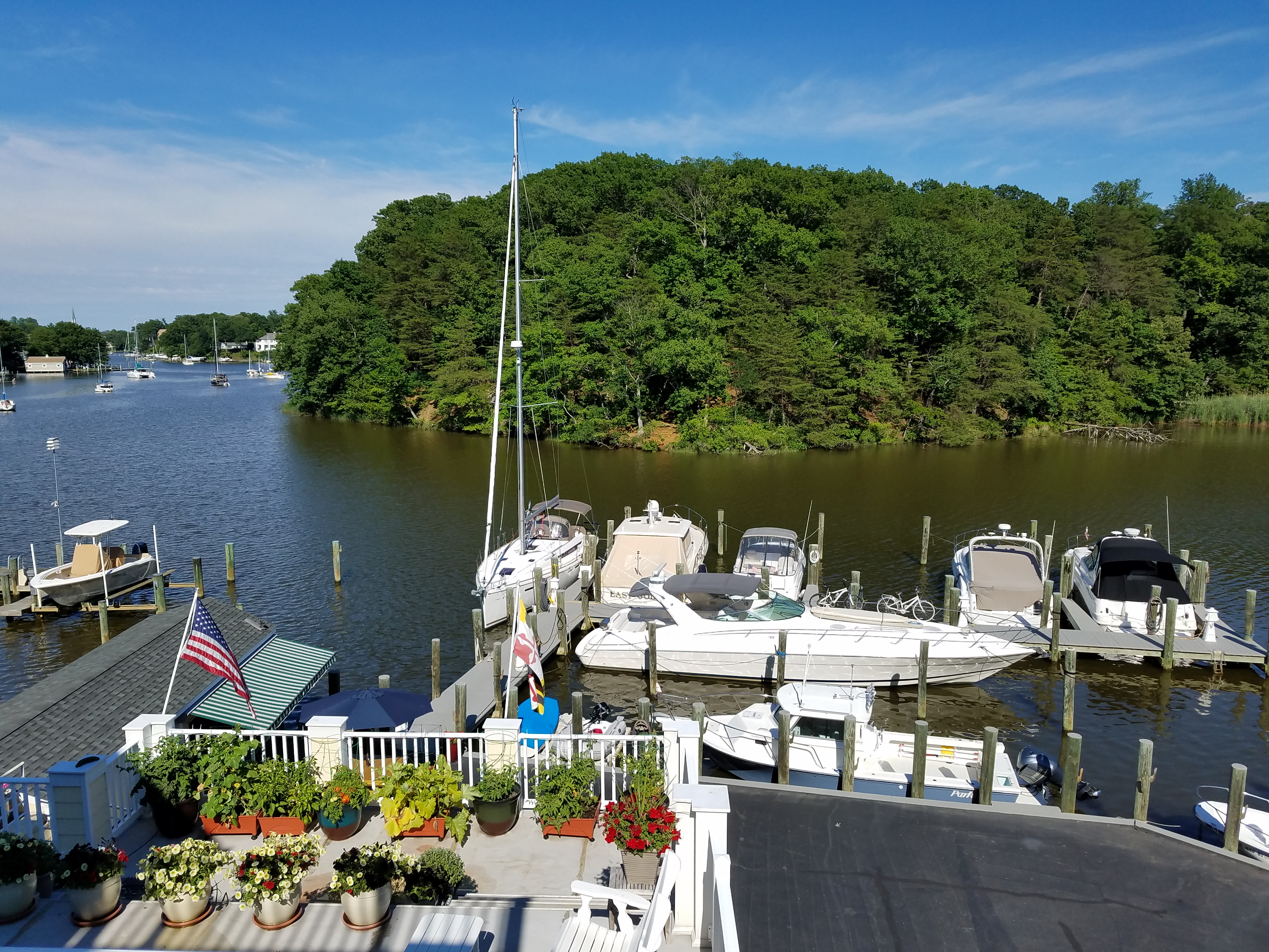 Boats moored at docks along a tree-lined creek