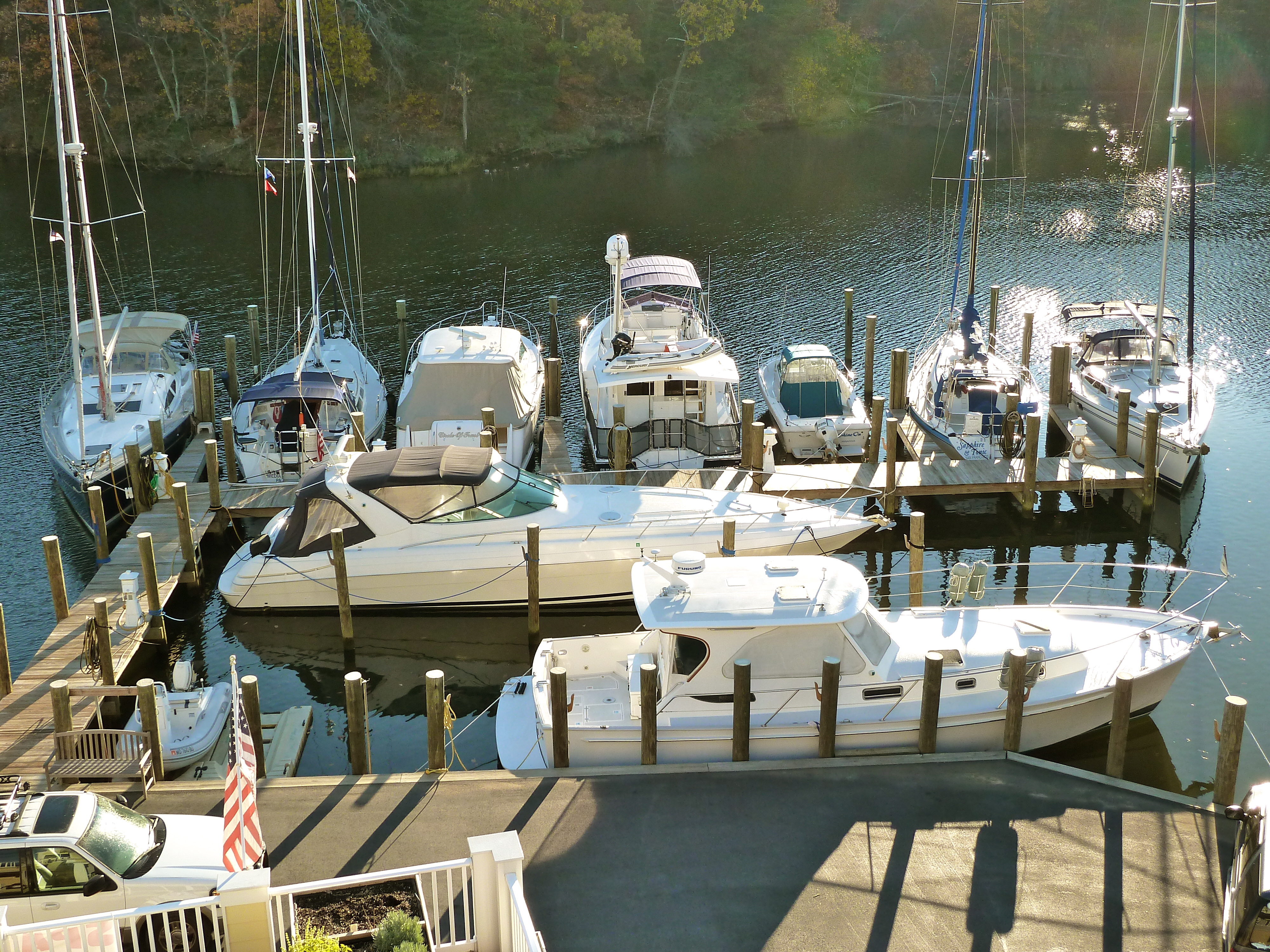 Sailboats and powerboats moored beside wooden docks